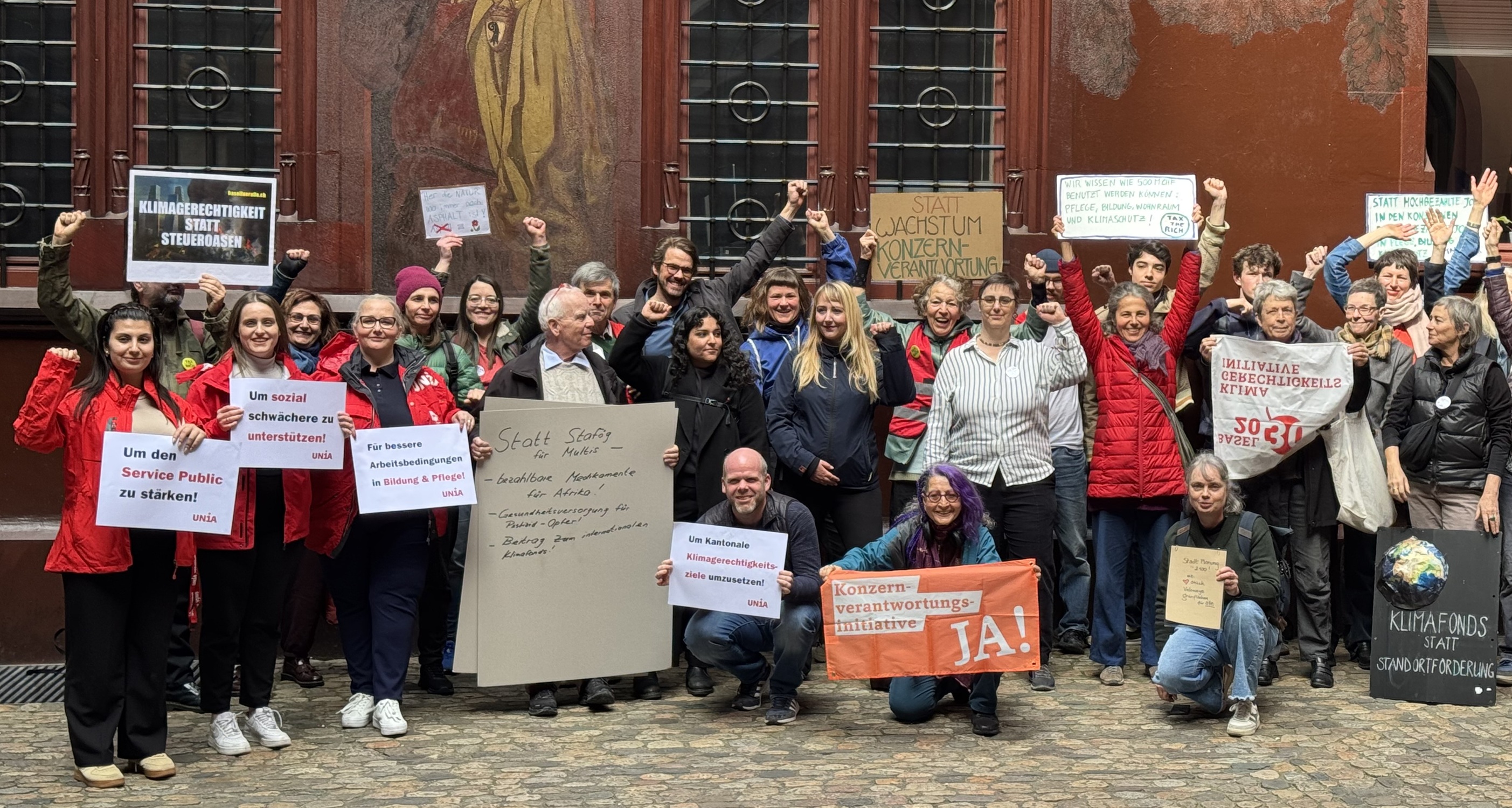 Das Referendumskomitee mit Transparenten im Hof des Rathauses